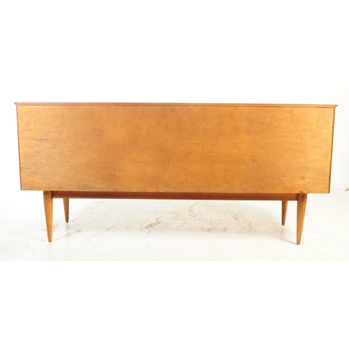 589 - British Modern Design - A mid 20th century teak veneer sideboard credenza. The sideboard raised on t... 