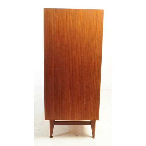 591 - British Modern Design - A mid 20th century teak veneer chest of drawers. The chest of drawers raised... 