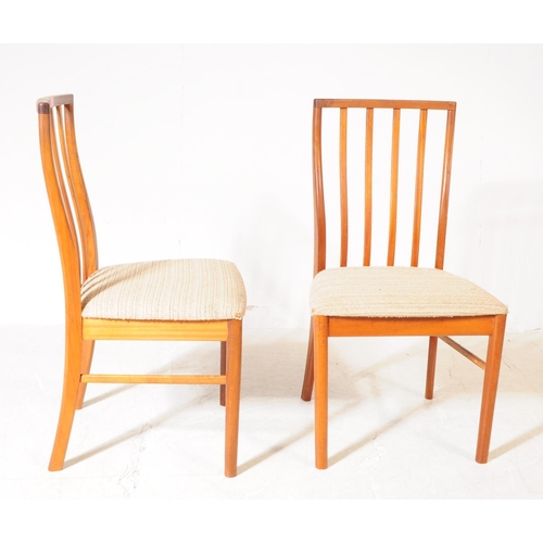 621 - Mcintosh - A set of four retro mid century teak dining chairs. Having slatted backrest on white upho... 