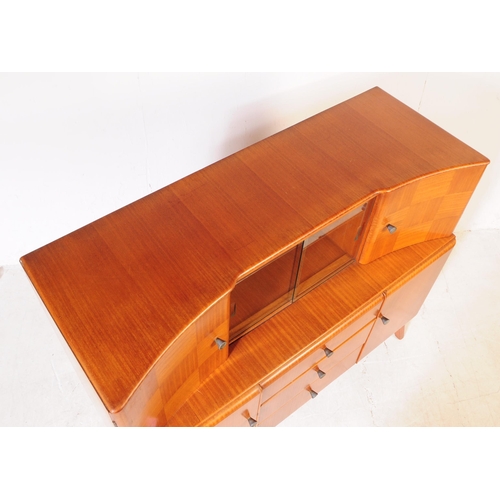 627 - Beautility Furniture - A mid century circa 1950s oak veneered sideboard credenza. Bow front top sect... 