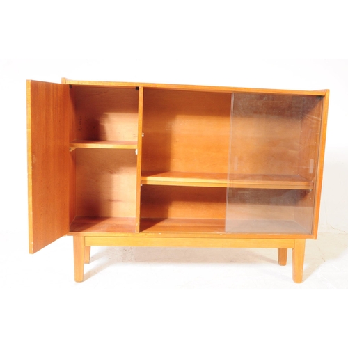 647 - British Modern Design - A mid 20th century teak glazed bookcase cabinet. The bookcase featuring a cu... 