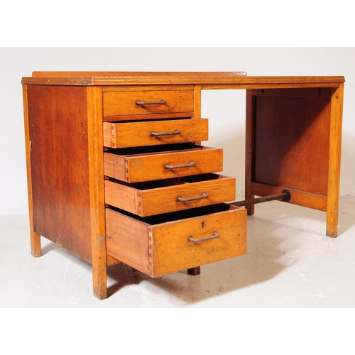 648 - A mid 20th century 1940s Air Ministry manner oak wood desk. The desk raised on block feet, having a ... 