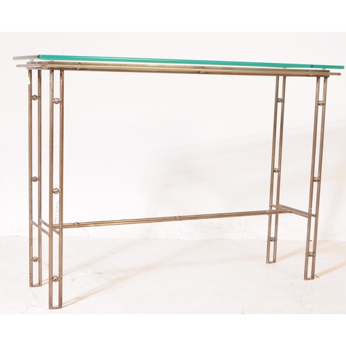 654 - A 20th century Italian manner metal and glass console hall table. The table featuring a metal frame,... 