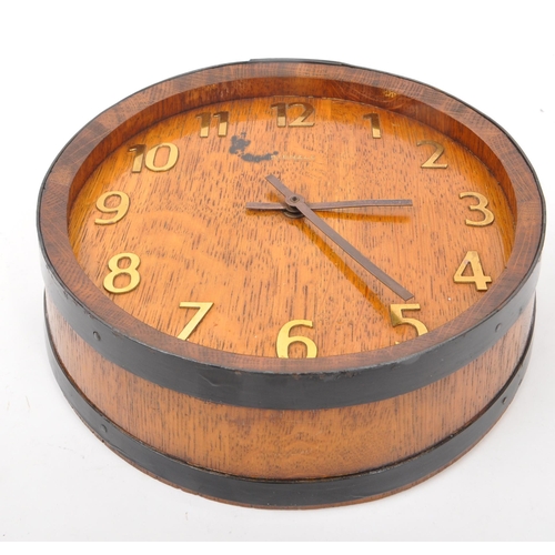 655 - A mid 20th century Kienzle barrel wall clock. The clock in the form of the top of a coopered barrel,... 