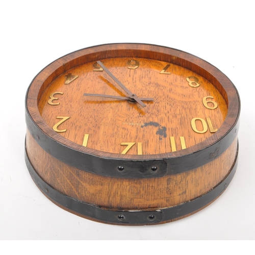 655 - A mid 20th century Kienzle barrel wall clock. The clock in the form of the top of a coopered barrel,... 