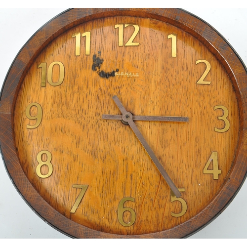 655 - A mid 20th century Kienzle barrel wall clock. The clock in the form of the top of a coopered barrel,... 