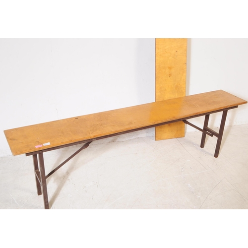 663 - A pair of mid 20th century folding trestle benches. The benches each having long rectangular ply top... 