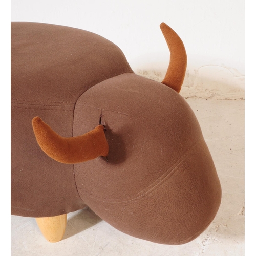 689 - A contemporary faux leather footstool ottoman in bull / cow form. All raised on turned wooden legs. ... 