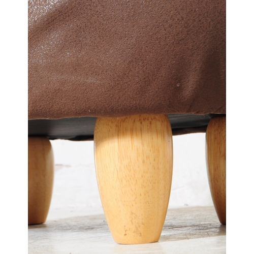 689 - A contemporary faux leather footstool ottoman in bull / cow form. All raised on turned wooden legs. ... 