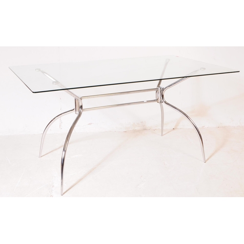 695 - A contemporary glass and chrome dining table. The base having sculptural tubular form legs with rect... 