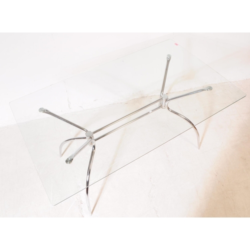 695 - A contemporary glass and chrome dining table. The base having sculptural tubular form legs with rect... 