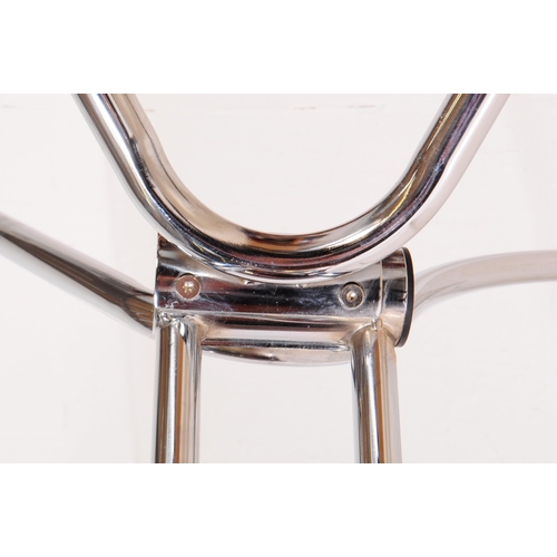 695 - A contemporary glass and chrome dining table. The base having sculptural tubular form legs with rect... 