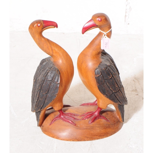 701 - Two 20th century carved wooden bird sculptures. The larger of the two in the form of two vultures wi... 