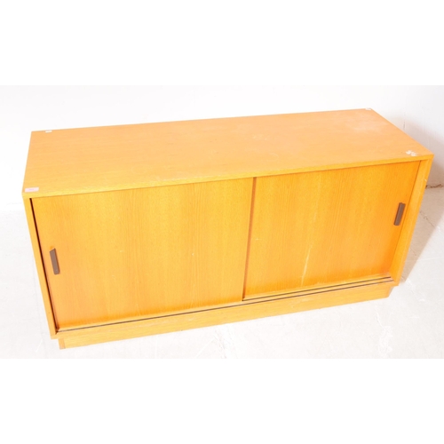 703 - British Modern Design - A mid 20th century teak sliding door cabinet sideboard. The sideboard raised... 