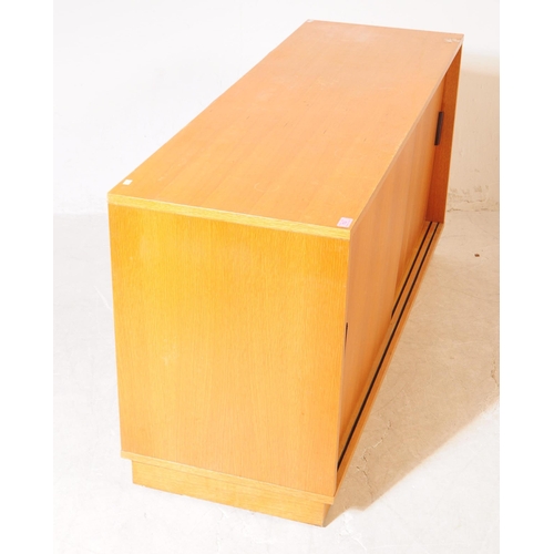 703 - British Modern Design - A mid 20th century teak sliding door cabinet sideboard. The sideboard raised... 