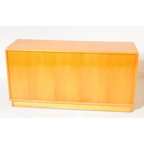 703 - British Modern Design - A mid 20th century teak sliding door cabinet sideboard. The sideboard raised... 