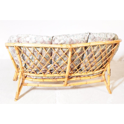 705 - A mid 20th century bamboo and wicker conservatory sofa settee. The sofa having a bent cane bamboo fr... 