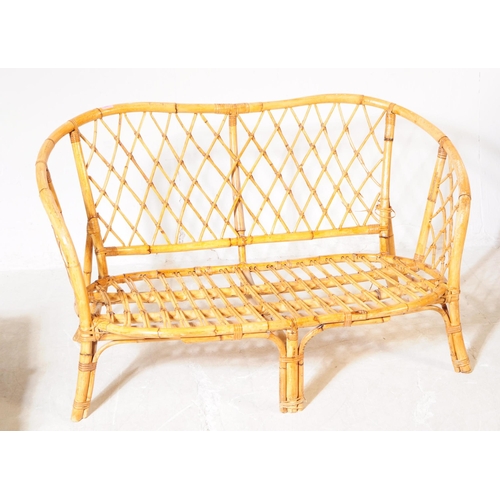 705 - A mid 20th century bamboo and wicker conservatory sofa settee. The sofa having a bent cane bamboo fr... 