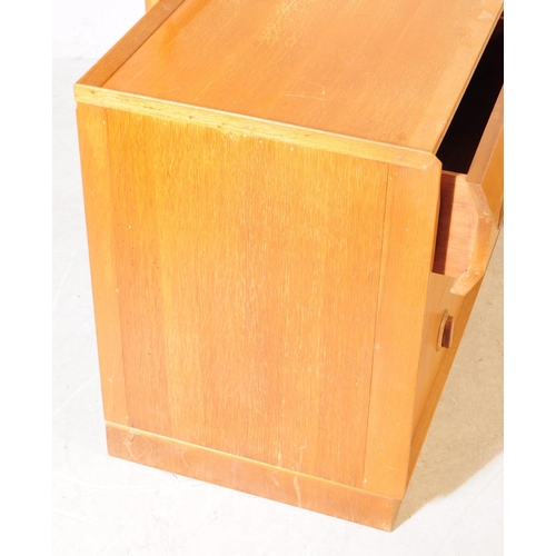 706 - British Modern Design - A mid 20th century oak veneer dressing chest of drawers. The chest of drawer... 