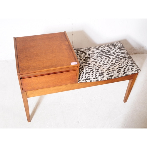 718 - British Modern Design - A mid 20th century circa 1960s teak Chippy telephone seat. The seat having d... 