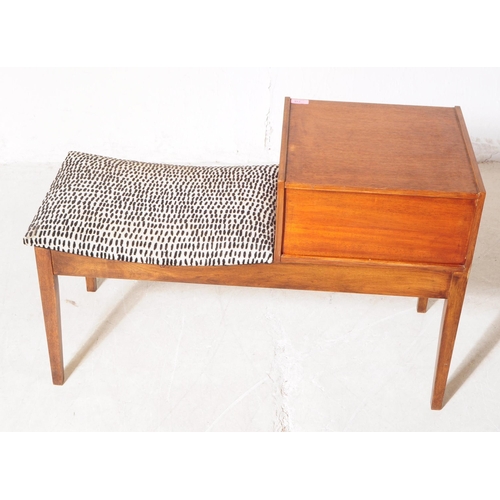 718 - British Modern Design - A mid 20th century circa 1960s teak Chippy telephone seat. The seat having d... 