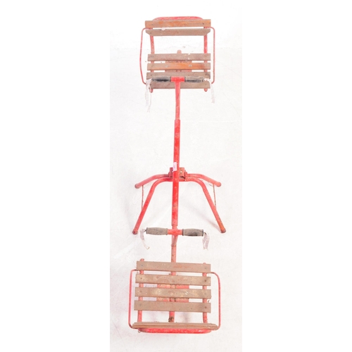 749 - A mid Century vintage children's outdoor metal seesaw painted red with wooden slatted seats having m... 