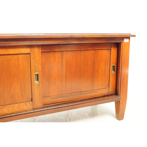 812 - A 20th century mahogany sideboard / credenza. Of rectangular form with flared top, over three slidin... 