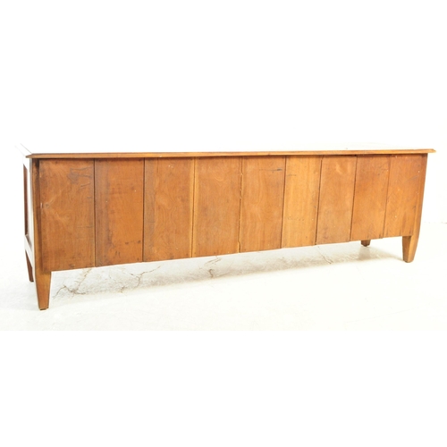 812 - A 20th century mahogany sideboard / credenza. Of rectangular form with flared top, over three slidin... 