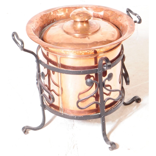 816 - A 19th century Victorian Arts & Crafts coal bucket with lid. In a cast iron stand with twin carry ha... 