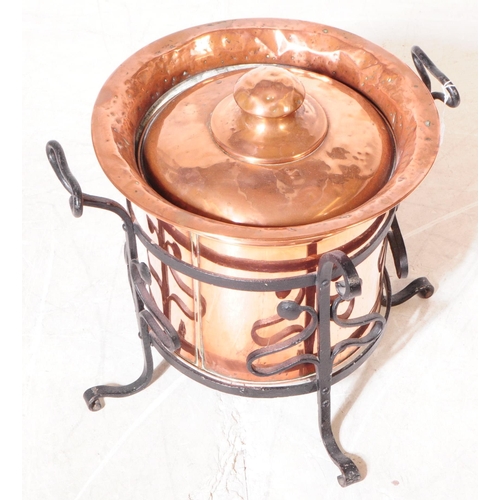 816 - A 19th century Victorian Arts & Crafts coal bucket with lid. In a cast iron stand with twin carry ha... 