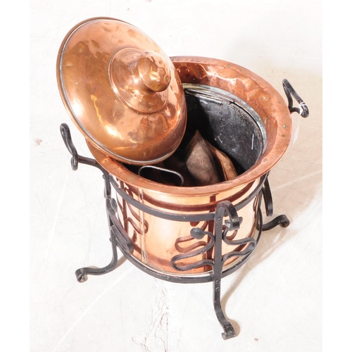 816 - A 19th century Victorian Arts & Crafts coal bucket with lid. In a cast iron stand with twin carry ha... 