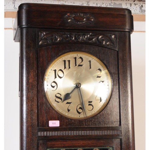 820 - An early 20th century circa 1930s Art Deco oak wood longcase grandfather clock. The clock raised on ... 