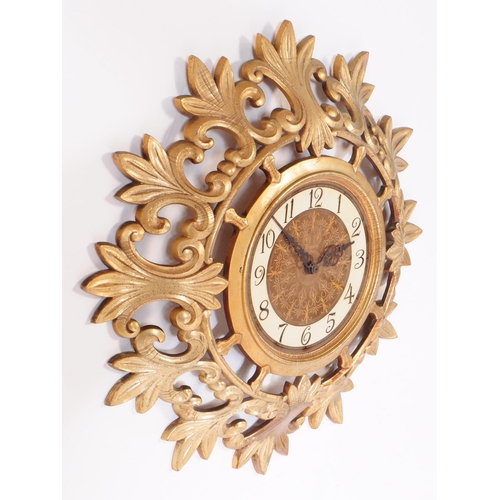 890 - A retro mid 20th century Syroco rococo style gilt wall clock. Syroco to front with ebonised chapter ... 