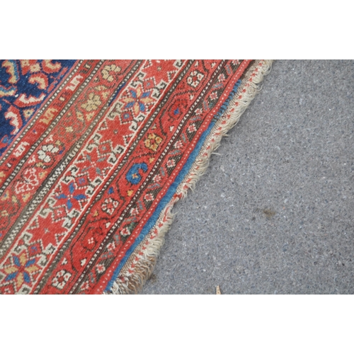 892 - A 20th century Persian runner carpet rug. The rug having a dark blue central field populated with po... 