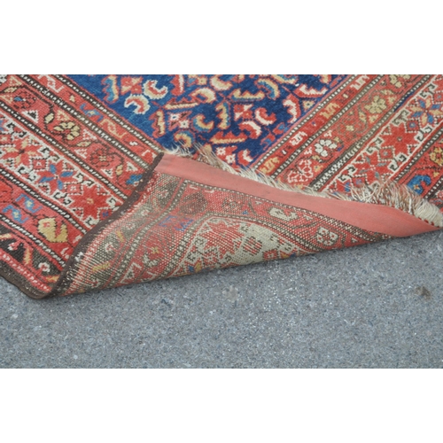 892 - A 20th century Persian runner carpet rug. The rug having a dark blue central field populated with po... 