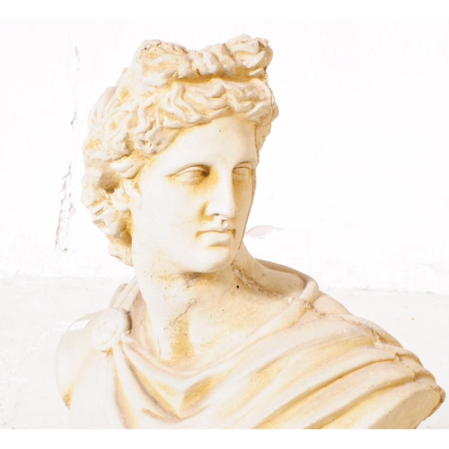 917 - A stone composite bust of Apollo. The bust raised on a rounded plinth, with upper torso and shoulder... 