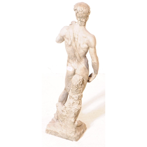 918 - A cast stone composite garden figure statue of Michelangelo's David. The figure stood upon a natural... 