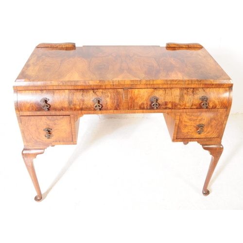 926 - An Art Deco figured walnut writing / dressing table / desk. Rectangular form with two curved paralle... 