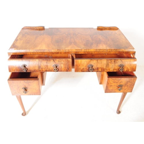 926 - An Art Deco figured walnut writing / dressing table / desk. Rectangular form with two curved paralle... 