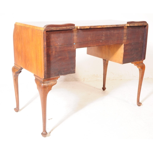 926 - An Art Deco figured walnut writing / dressing table / desk. Rectangular form with two curved paralle... 