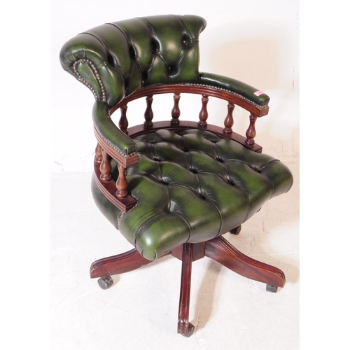 928 - A 20th century green leather captains desk chair / swivel armchair. The chair raised on a splayed ba... 