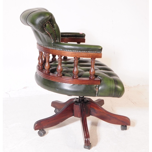 928 - A 20th century green leather captains desk chair / swivel armchair. The chair raised on a splayed ba... 