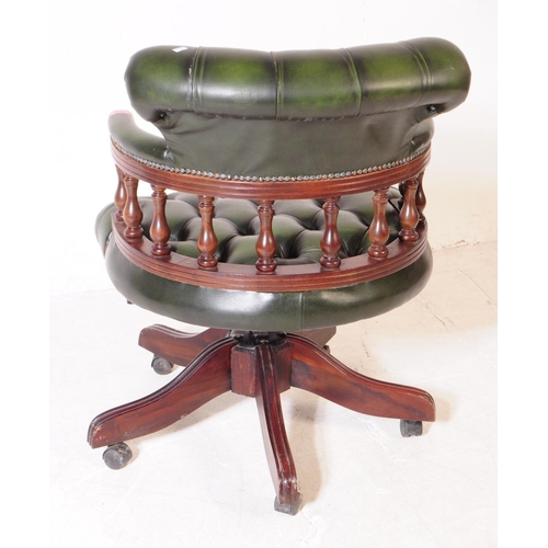 928 - A 20th century green leather captains desk chair / swivel armchair. The chair raised on a splayed ba... 