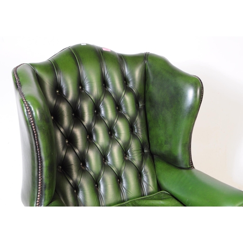 930 - Chesterfield style - A 20th Century green leather Chesterfield manner wingback armchair. Raised on c... 