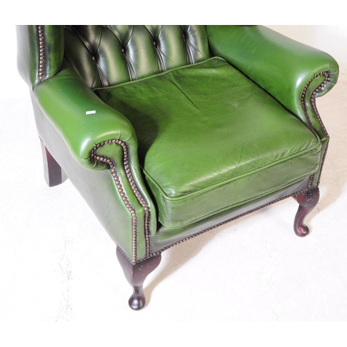 930 - Chesterfield style - A 20th Century green leather Chesterfield manner wingback armchair. Raised on c... 