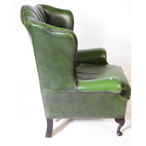 930 - Chesterfield style - A 20th Century green leather Chesterfield manner wingback armchair. Raised on c... 