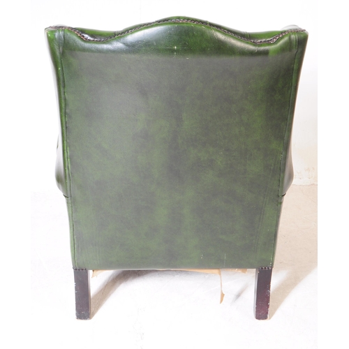 930 - Chesterfield style - A 20th Century green leather Chesterfield manner wingback armchair. Raised on c... 