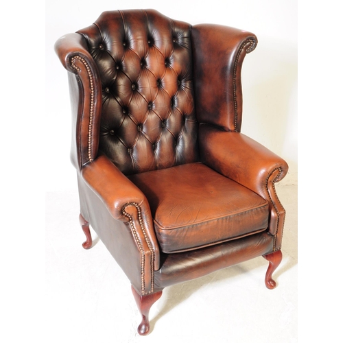 932 - Chesterfield style - A 20th Century brown leather Chesterfield manner wingback armchair. Raised on c... 