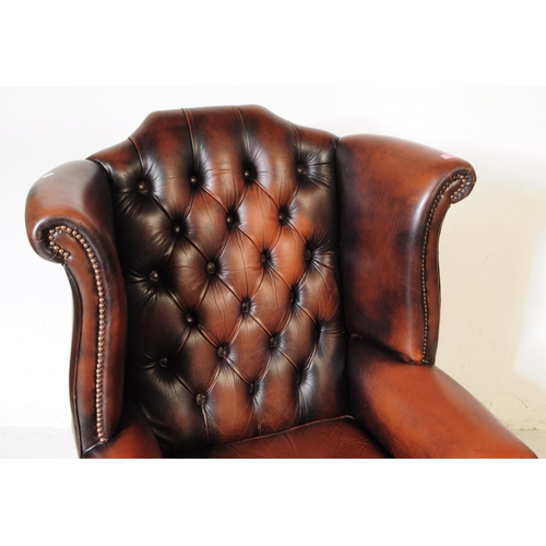 932 - Chesterfield style - A 20th Century brown leather Chesterfield manner wingback armchair. Raised on c... 