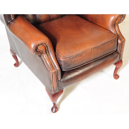 932 - Chesterfield style - A 20th Century brown leather Chesterfield manner wingback armchair. Raised on c... 